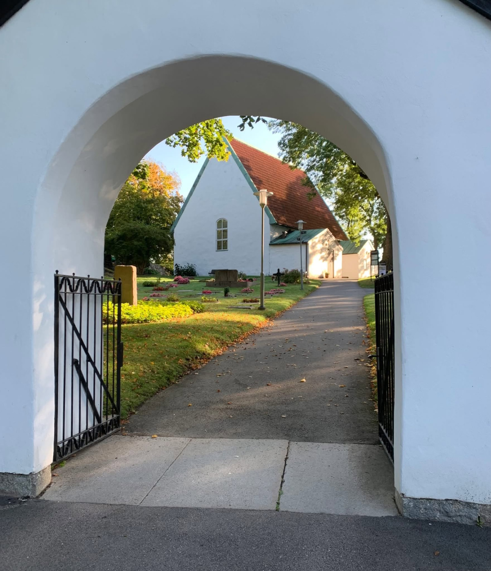 Lundby gamla kyrka sedd genom grinden till kyrkogården